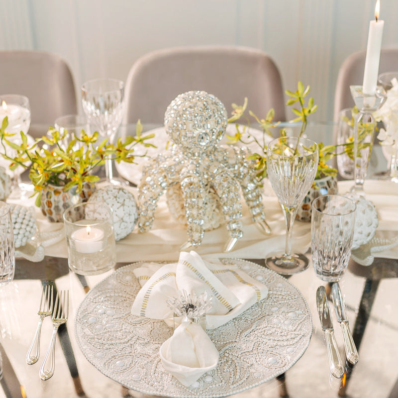 table setting with crystal octopus figurine and placemat on table