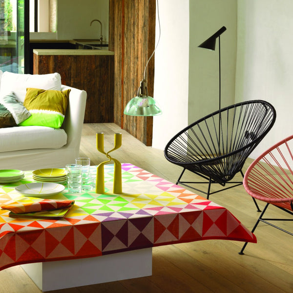 Le Jacquard Français Origami multicolor cotton tablecloth with geometric jacquard pattern on a coffee table in a rustic living room
