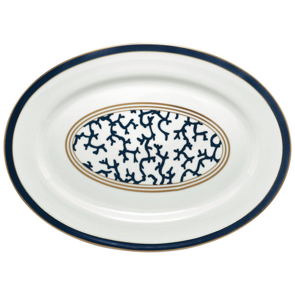 An oval-shaped Raynaud porcelain platter with a marine blue border and an intensive gold central pattern featuring coral branch shapes.