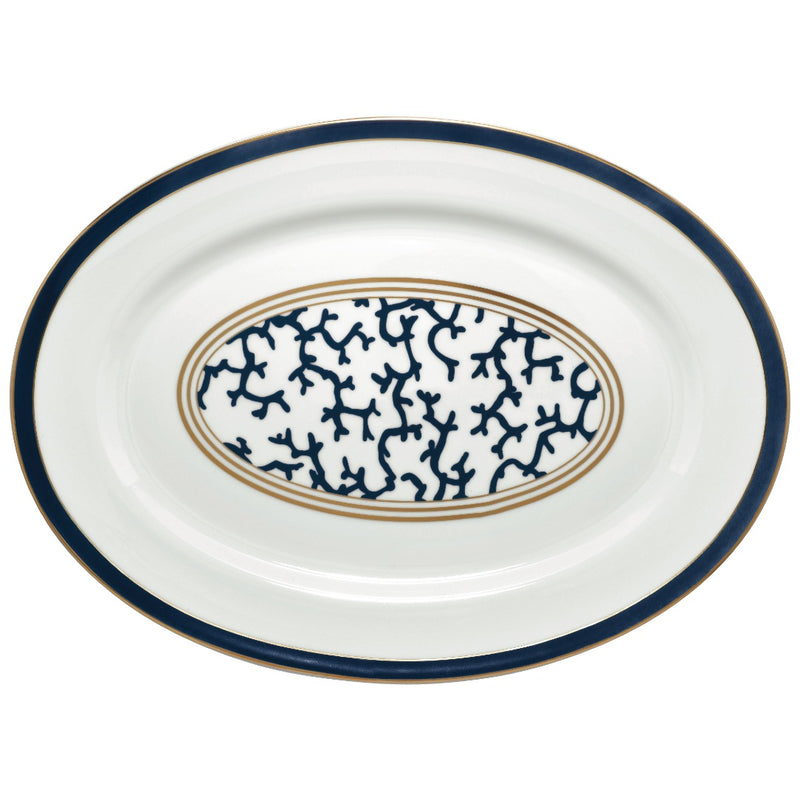 An oval-shaped Raynaud porcelain platter with a marine blue border and an intensive gold central pattern featuring coral branch shapes.