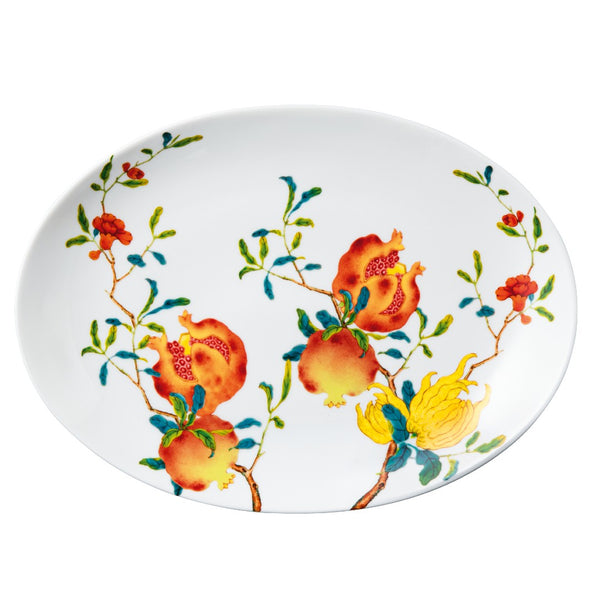 An oval porcelain platter with a colorful floral pattern, featuring a central pomegranate design and borders with a yellow and red color scheme.