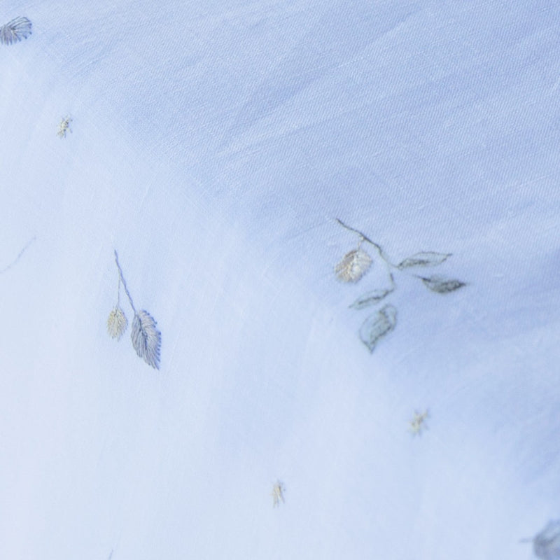 Close-up of Alexandre Turpault Ovni white linen tablecloth with minimalist embroidery