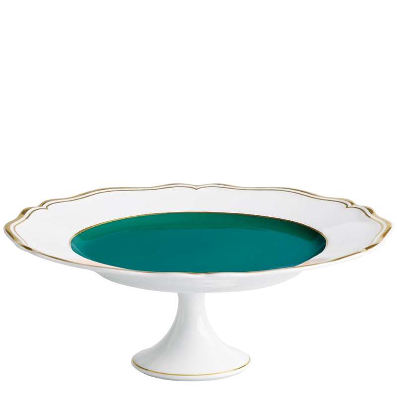 A porcelain cake stand with a scalloped edge and gold detailing, featuring a turquoise interior.