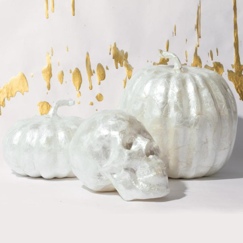 3 capiz decorative pumpkins and skull in white with specs of gold in the background