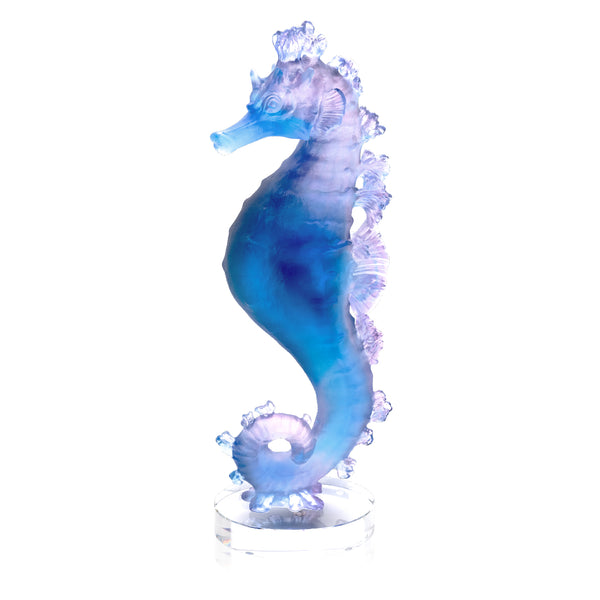 A crystal sculpture of a seahorse in blue and pink colors.
