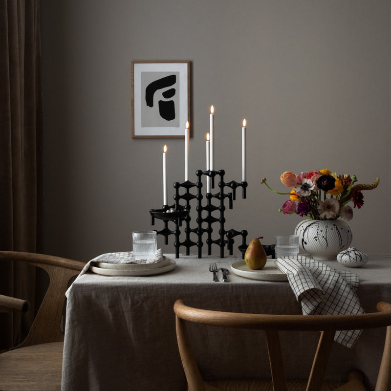 styled table with sculptural packs of matte black stoff nagel candle holder