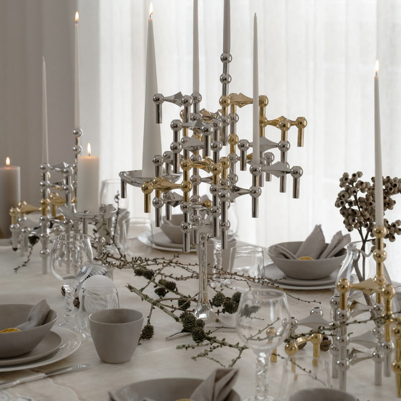 styled modern table with stacked candle holders in brass and chrome from Stoff Nagel