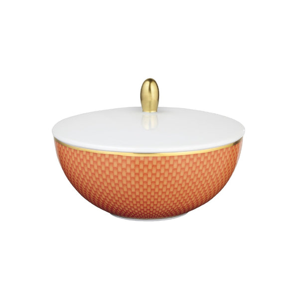 A porcelain sugar bowl with an orange pattern, featuring a honeycomb motif and gold accents, and a white lid with a gold handle.