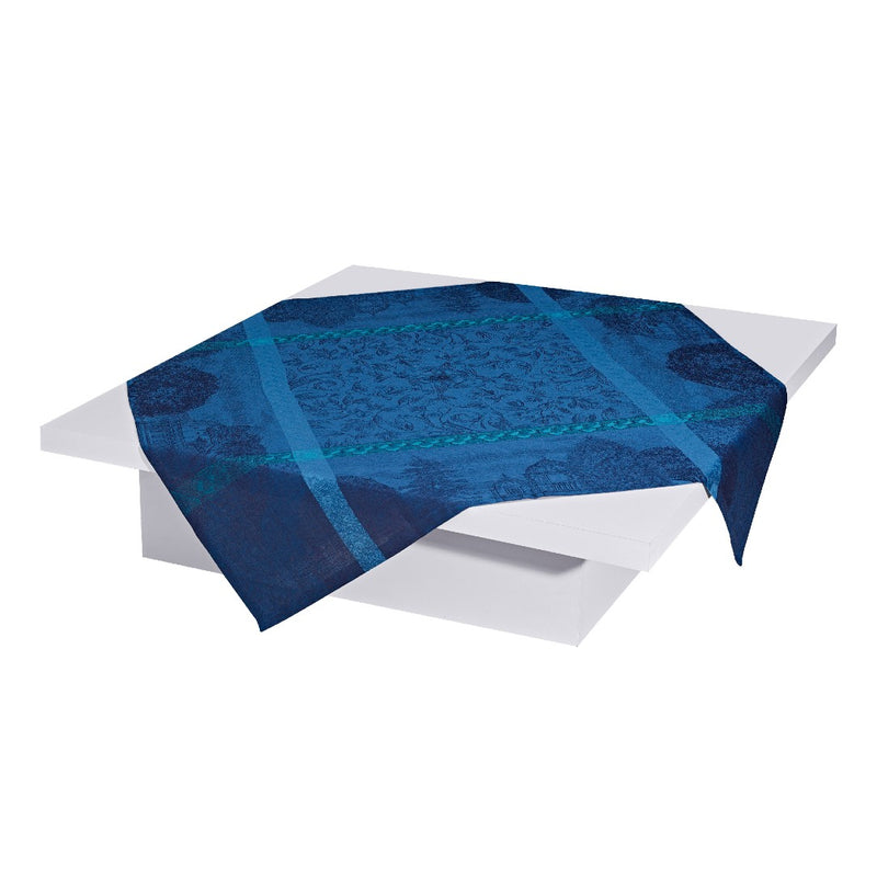 Le Jacquard Français Symphonie Baroque blue cotton tablecloth with ornate jacquard pattern on a white table