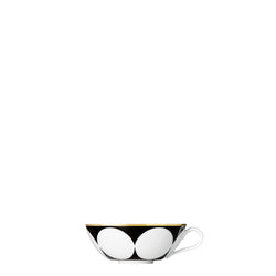 A coup-shaped porcelain tea bowl with a black and gold color scheme and geometric patterns, including stripes, squares, and circles.