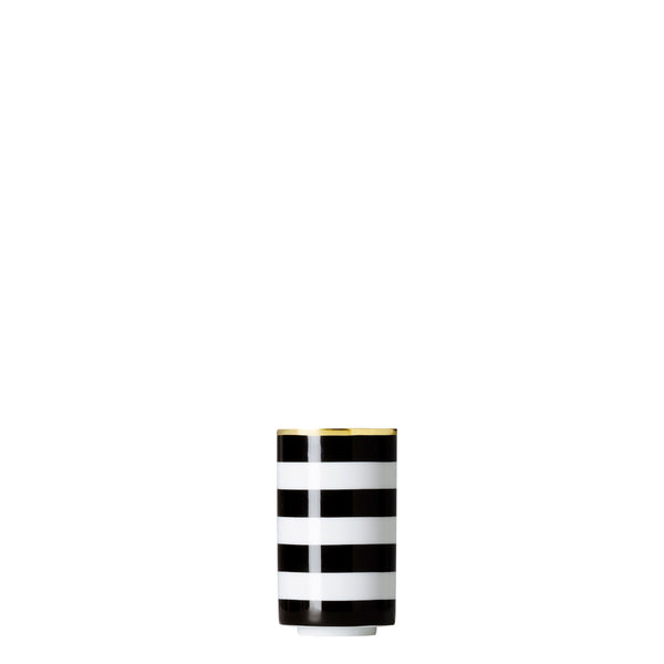 A cylindrical porcelain tea strainer beaker with black and gold stripes on a white background.
