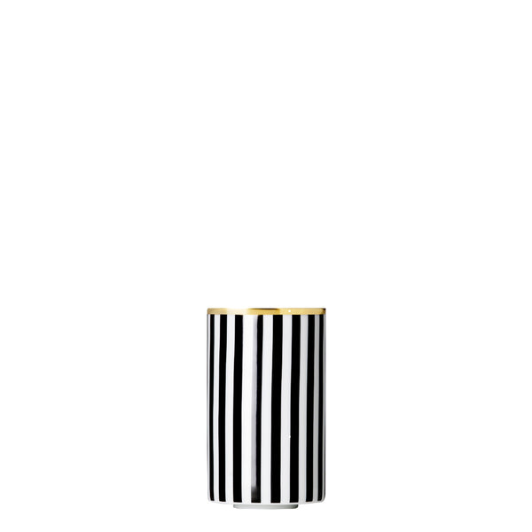 A cylindrical porcelain tea strainer beaker with black and gold stripes and geometric patterns.