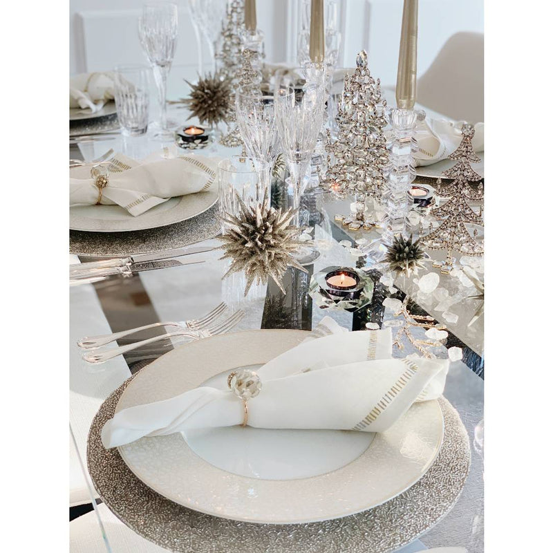 Table decoration with Christmas decor featuring crystal trees, glittery balls, napkins and napkin rings