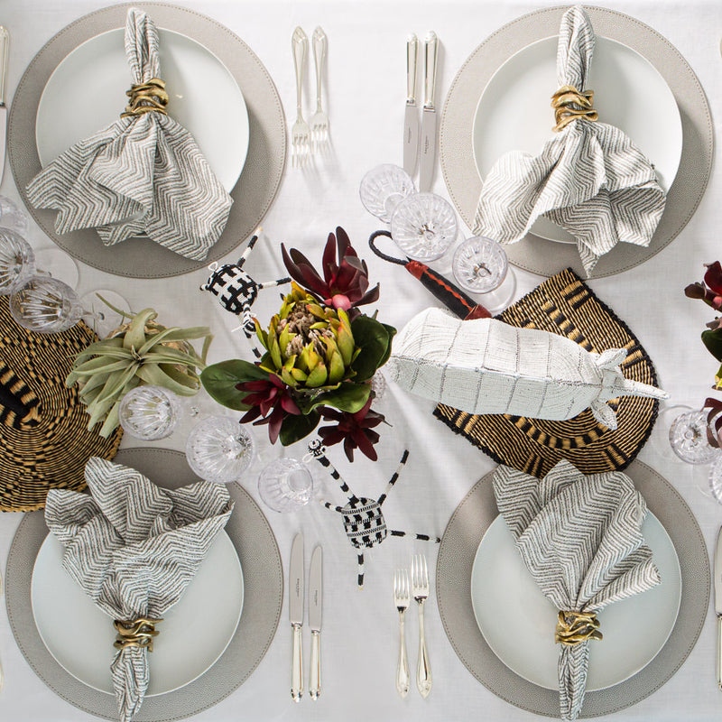 table decor showing safari decor with white rhino and grey placemats and protea flower