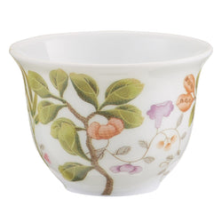 A porcelain coffee or tea cup with green, brown, and turquoise floral patterns on a white background.